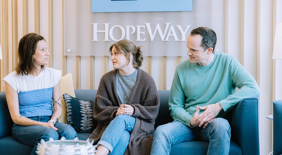 young woman on couch with parents