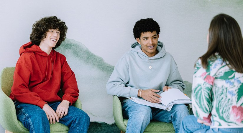 two teens sitting with counselor 